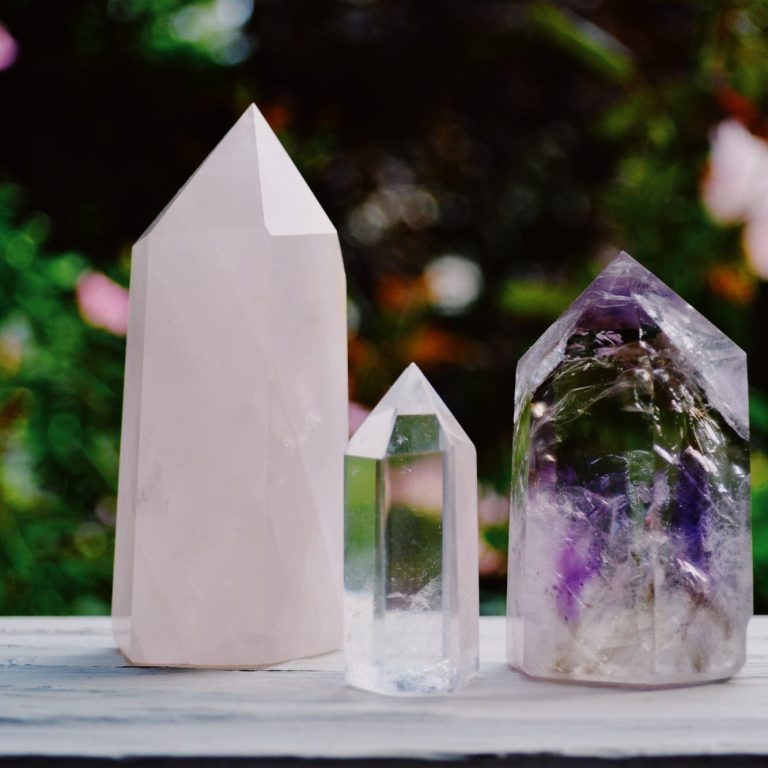 Trois cristaux pyramidaux en pierre Trois cristaux de formes pyramidales, en quartz rose, cristal transparent et améthyste.